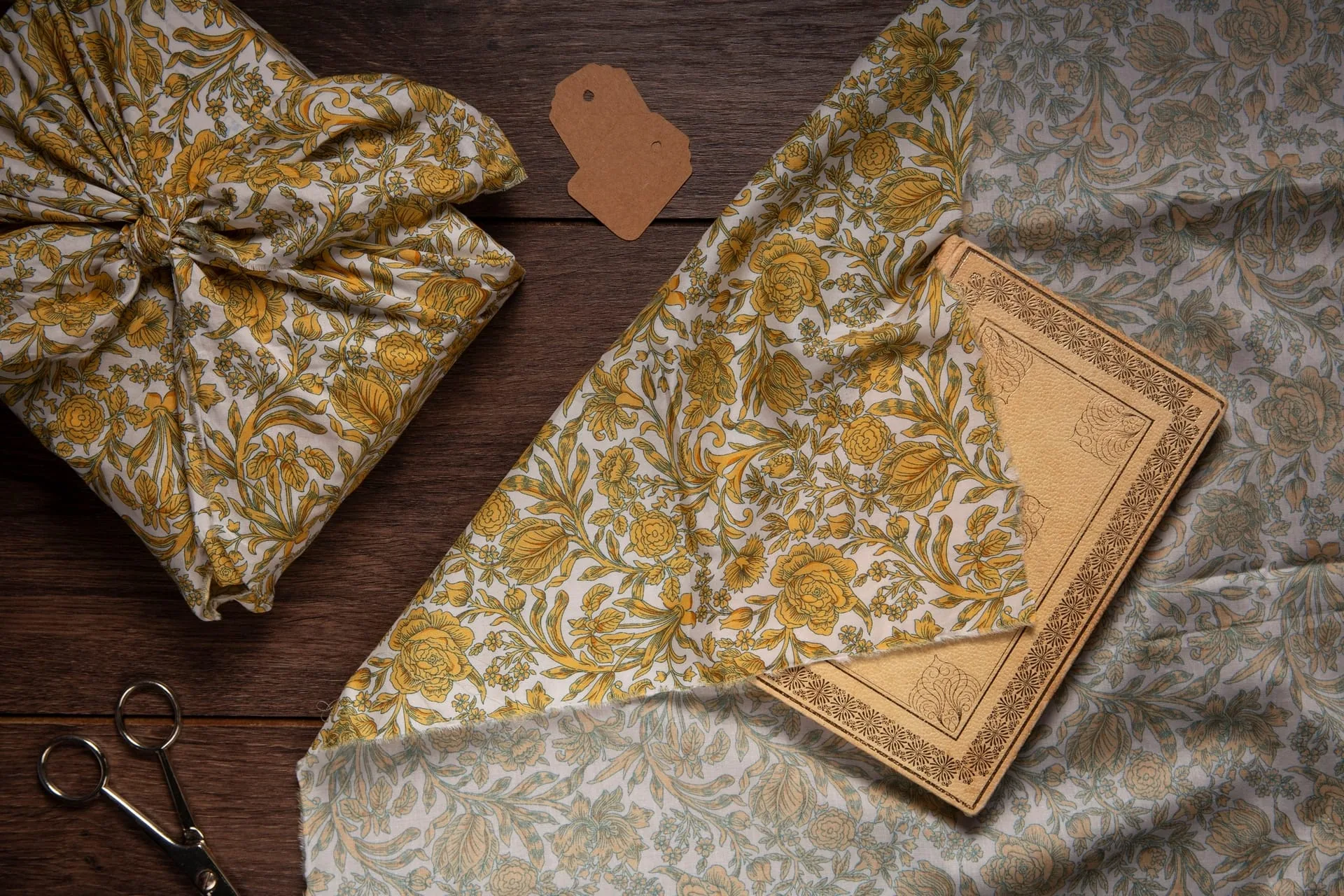 Folded silk scarves in soft seasonal hues laid gently across linen