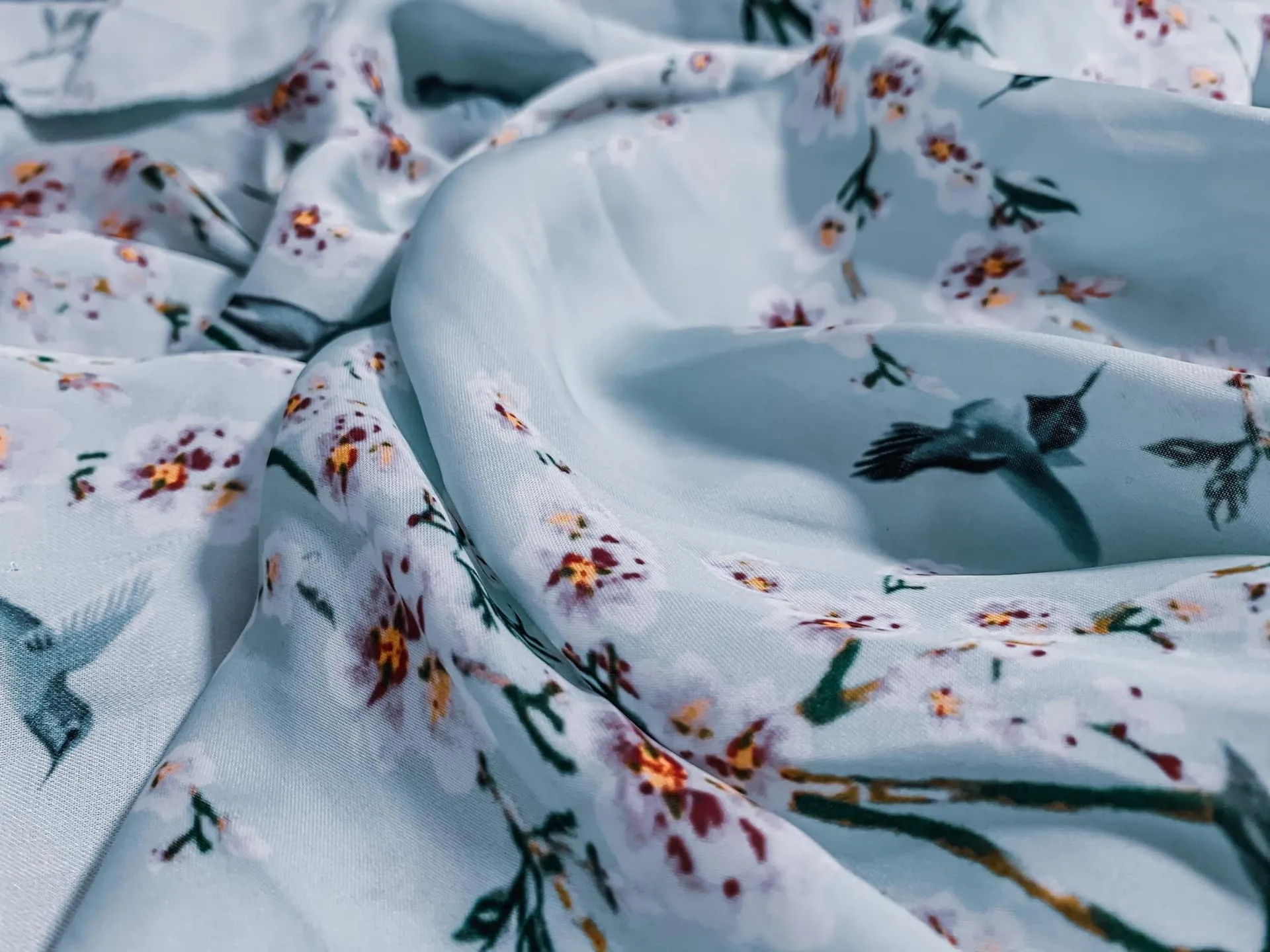 Three folded fabrics of varying weight and sheerness arranged together